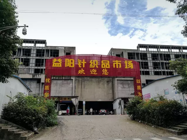 （2017年7月11日，湖南益阳，烂尾的“五角大楼”一侧建起一排临时商铺。图/《财经》记者 鲁伟）