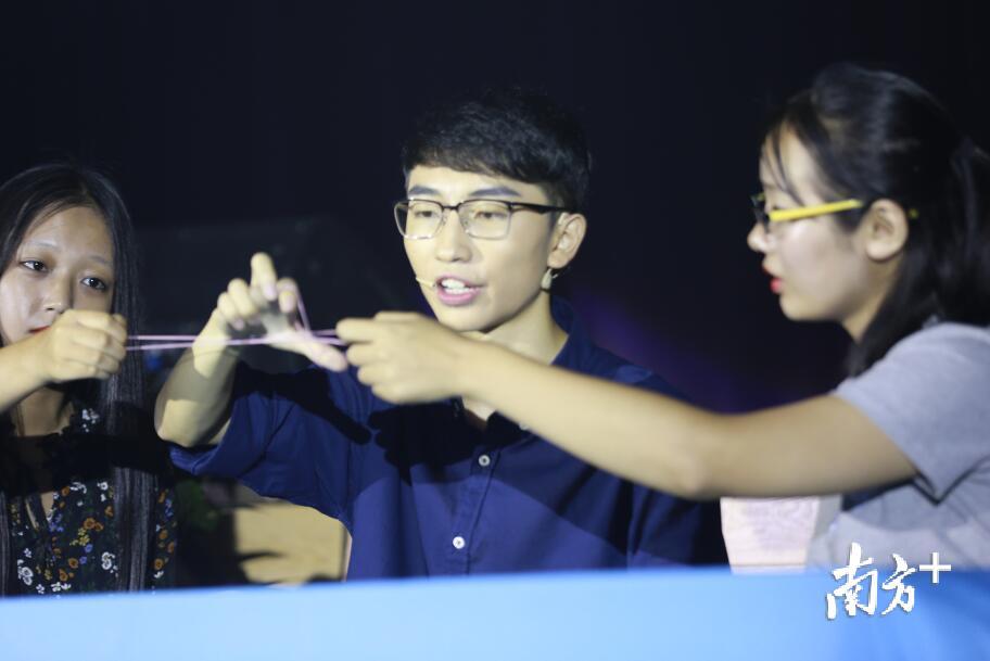 “小刘谦”在表演橡皮筋魔术。