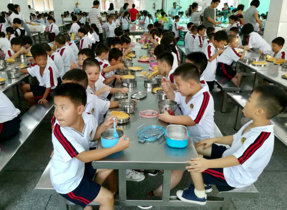 西南中心小学学生在食堂吃饭。