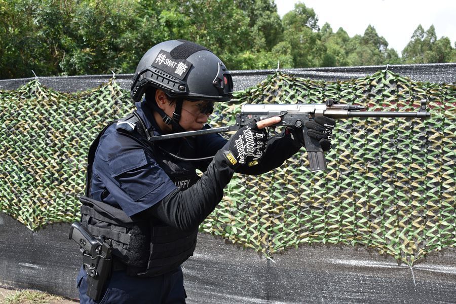 广州特警射击训练场,一个身着防弹衣,武装靴,头戴钢盔的女特警,长短