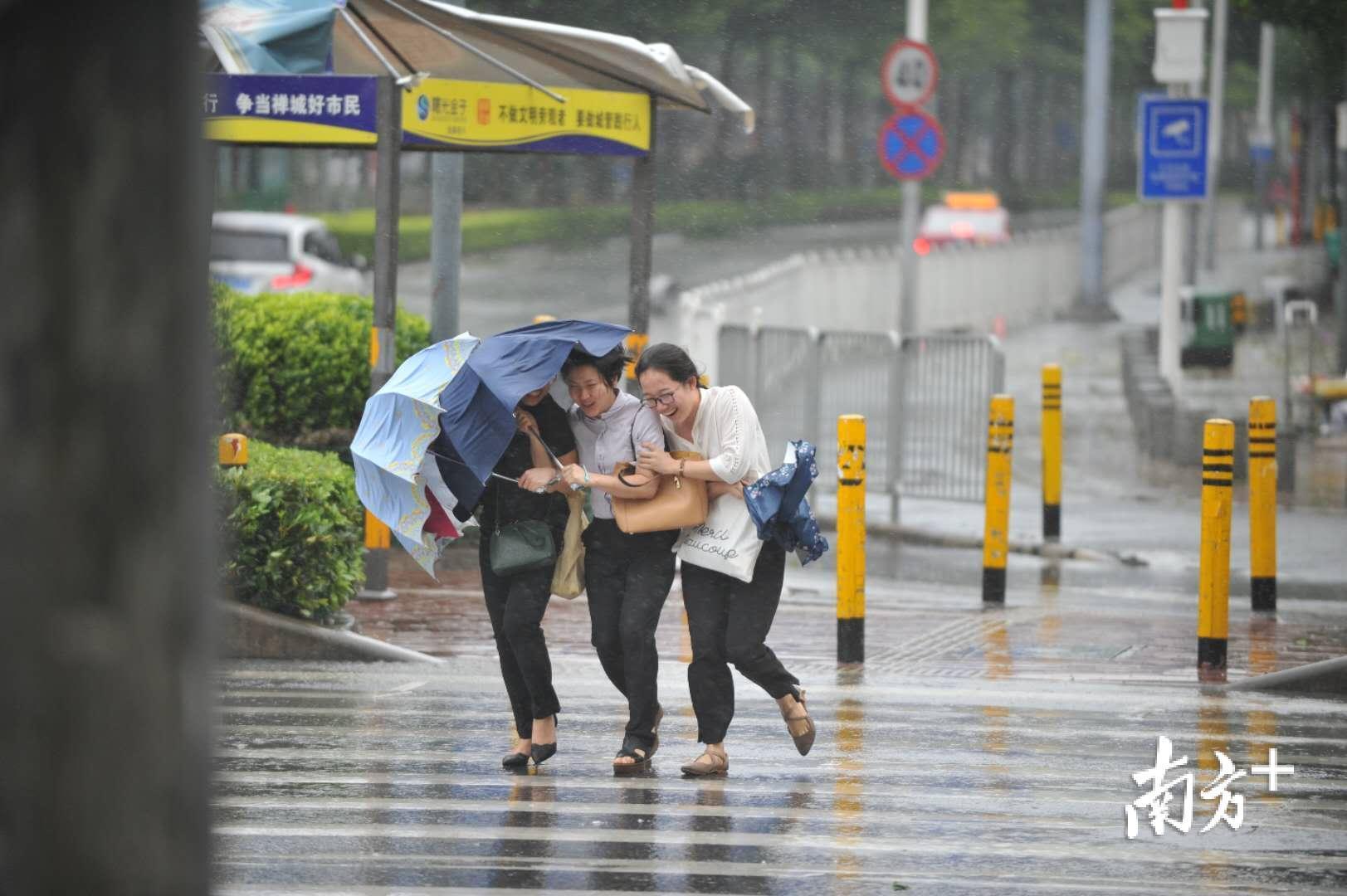 台风天却忘记带伞的市民只能和朋友"挤一挤".南方日报记者 戴嘉信 摄