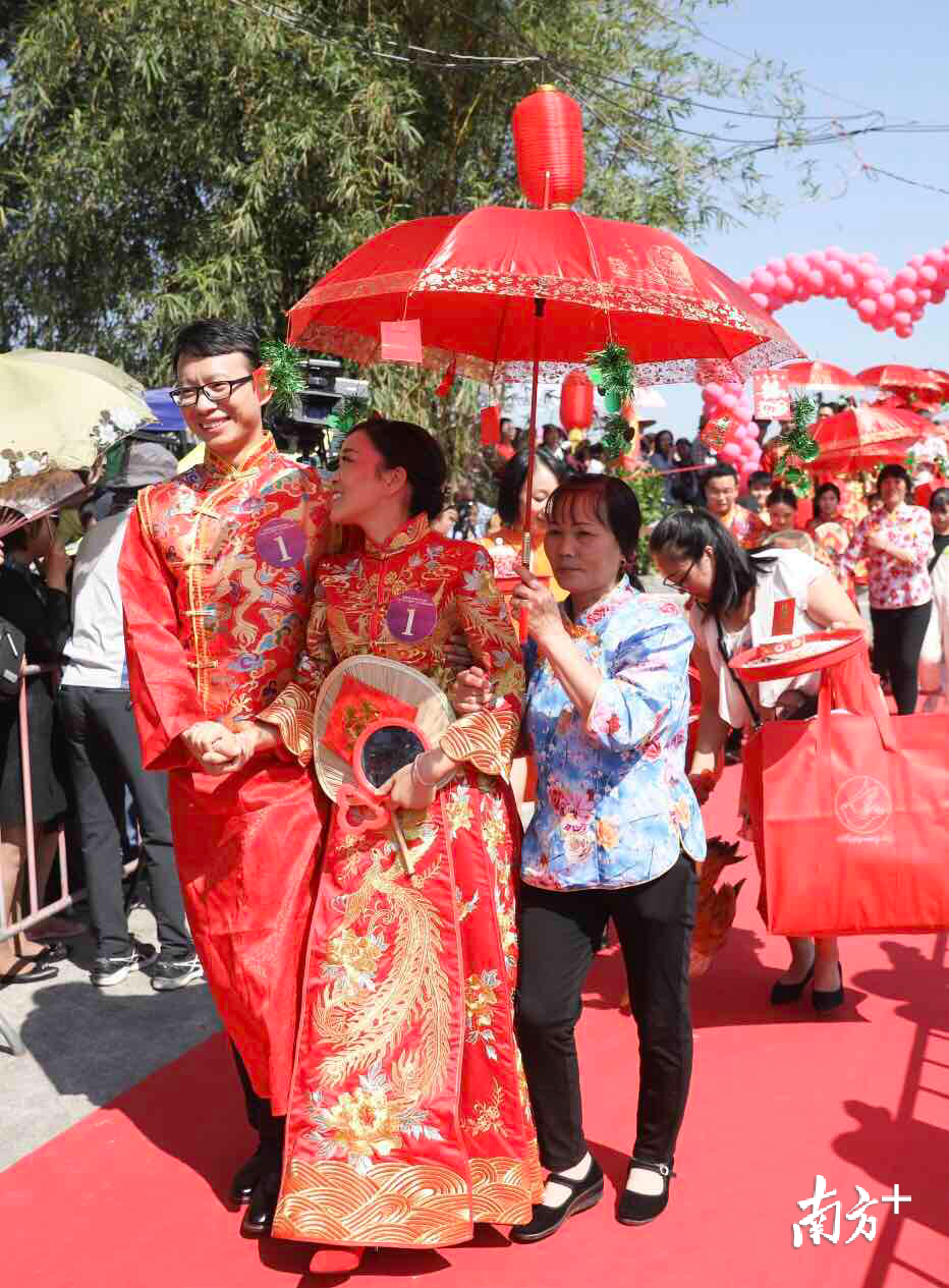 大批市民夹道围观,气氛热烈,新娘子害羞的依偎在新郎怀里,满脸幸福.