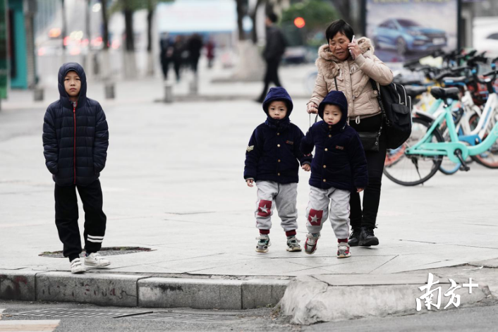 最佳颁给这位奶奶:这么冷的天,一个人出来接小孩放学,还是"一拖三,向