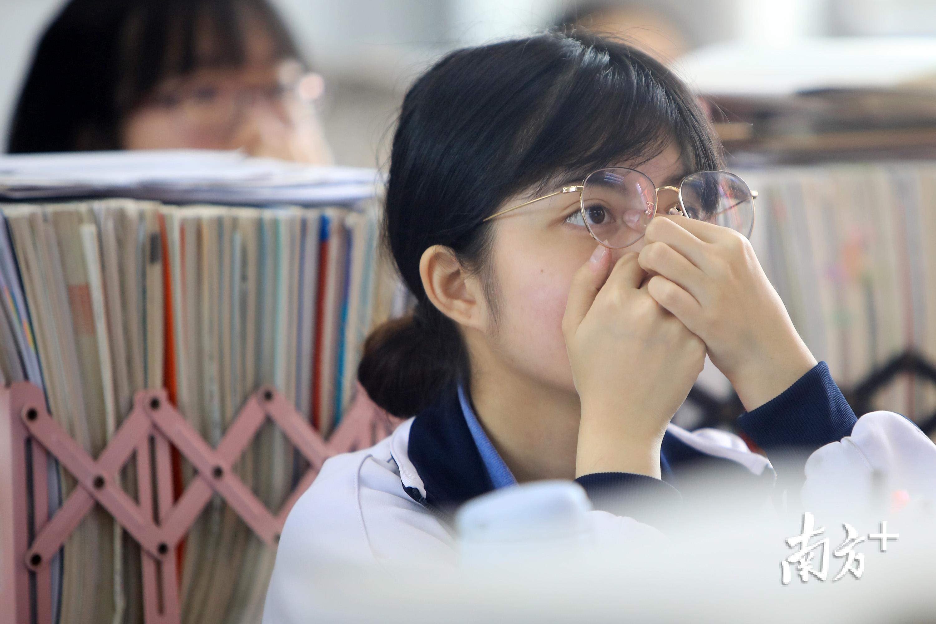 深圳高级中学东校区,一名高三学生一边听讲一边揉眼缓解疲劳.