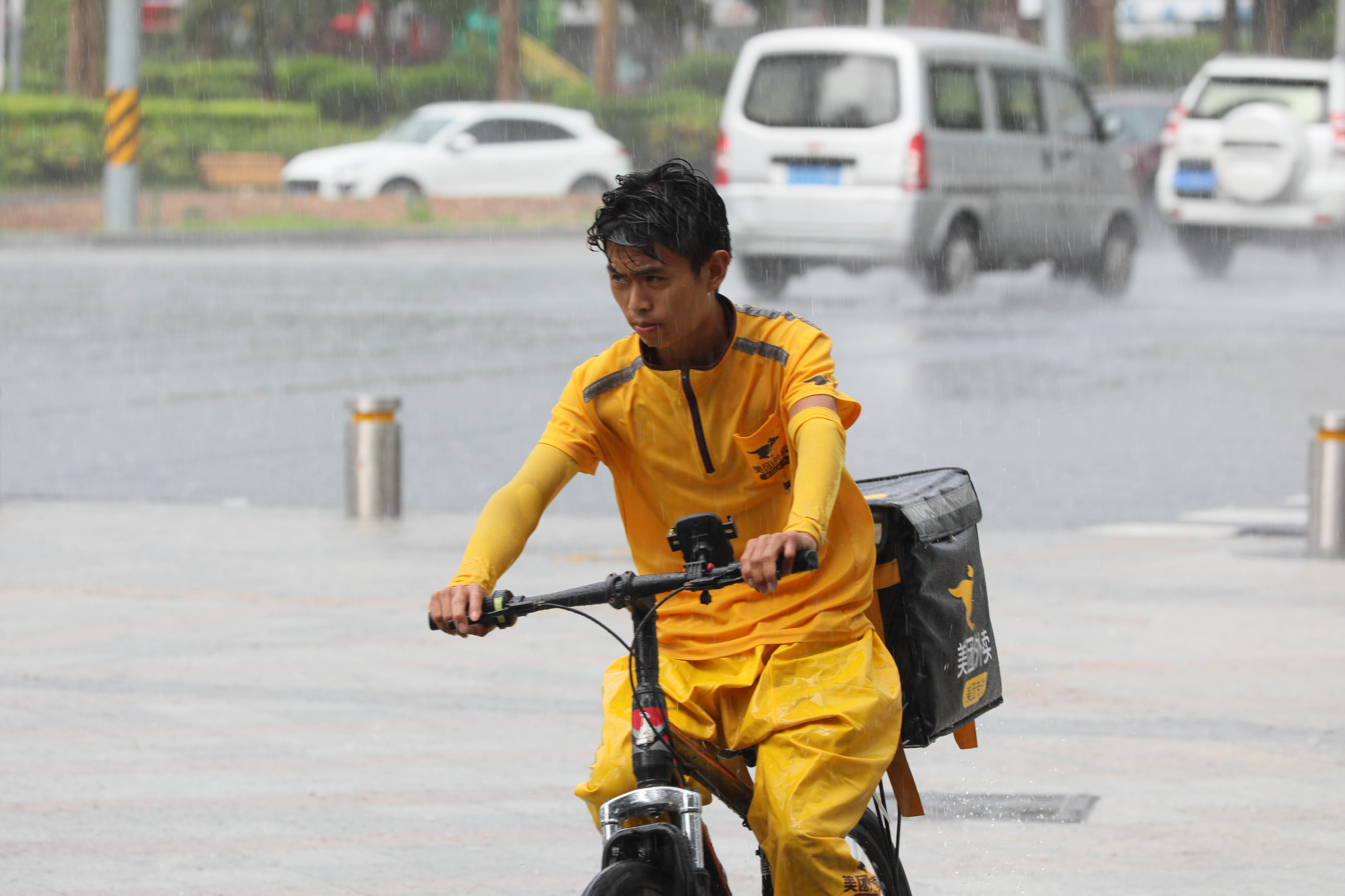 快递小哥冒雨前行.