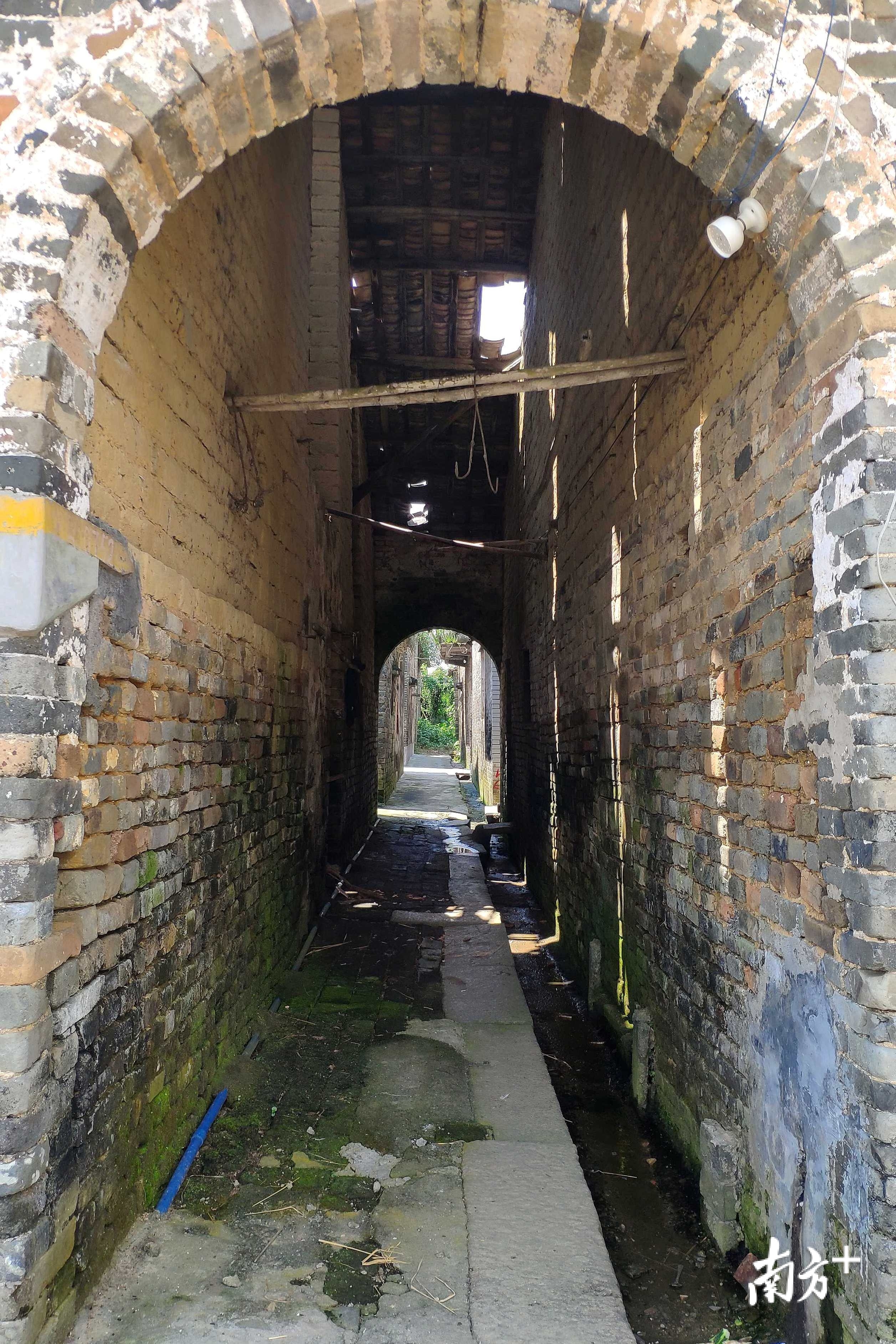 阳光透过屋顶的缝隙照在古村内的小巷。