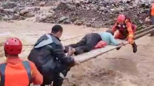 郑州暴雨一伤者被困景区，消防员搭建简易桥护送过河