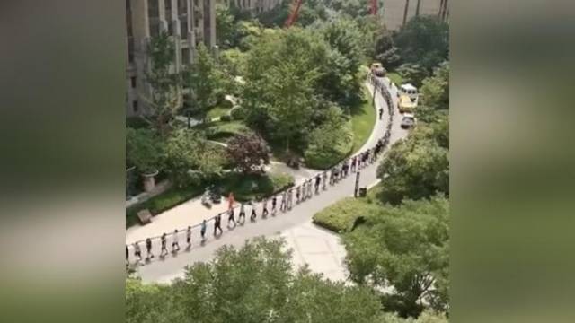 郑州停电停水小区居民自发排长龙扛电缆，为抢修队员搭把手