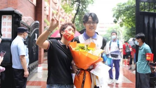 部分高考生结束考试，广州高考考点外家长们手捧鲜花犹如花海