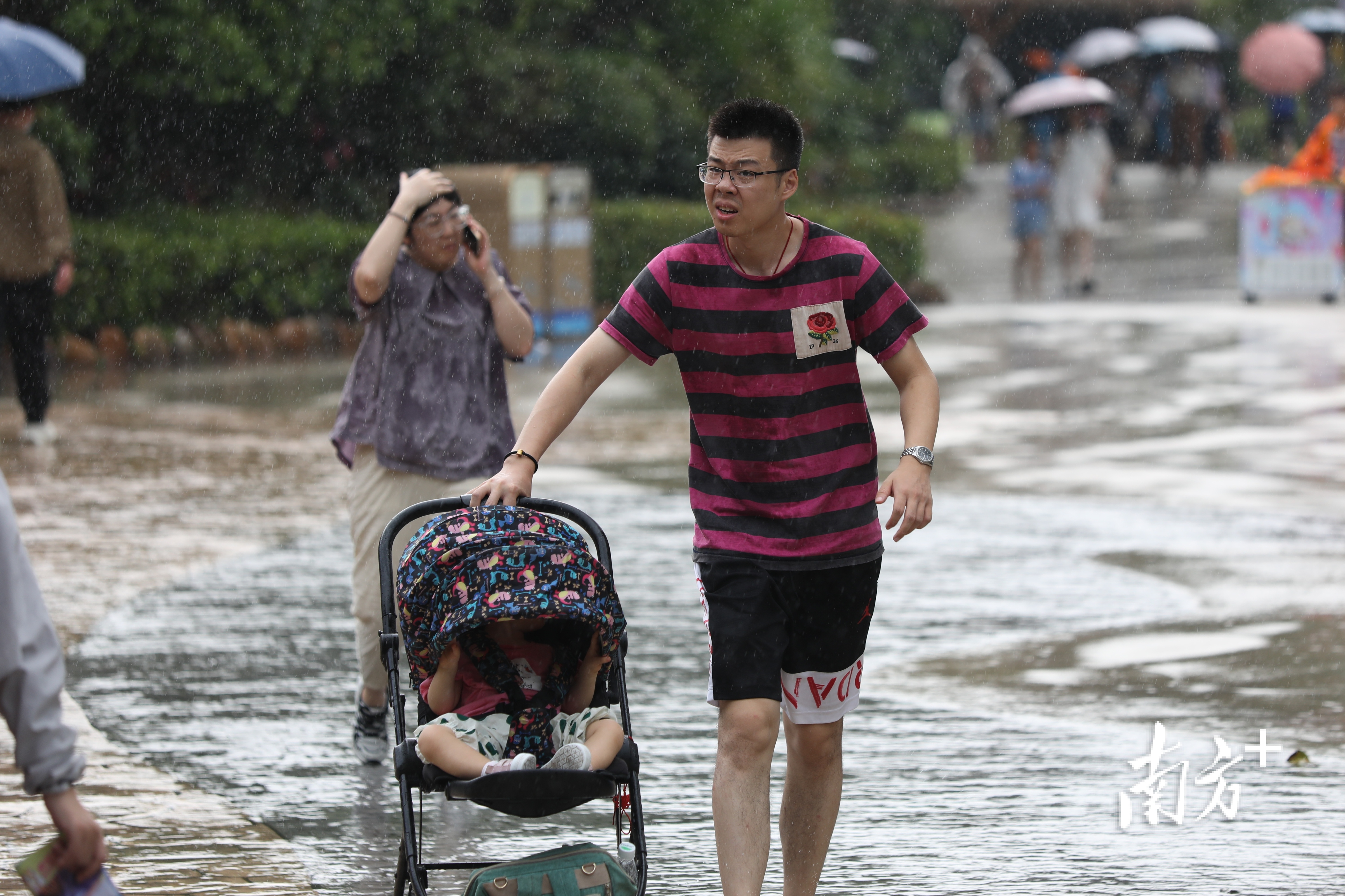 一家三口被突如其来的大雨淋了个措手不及。