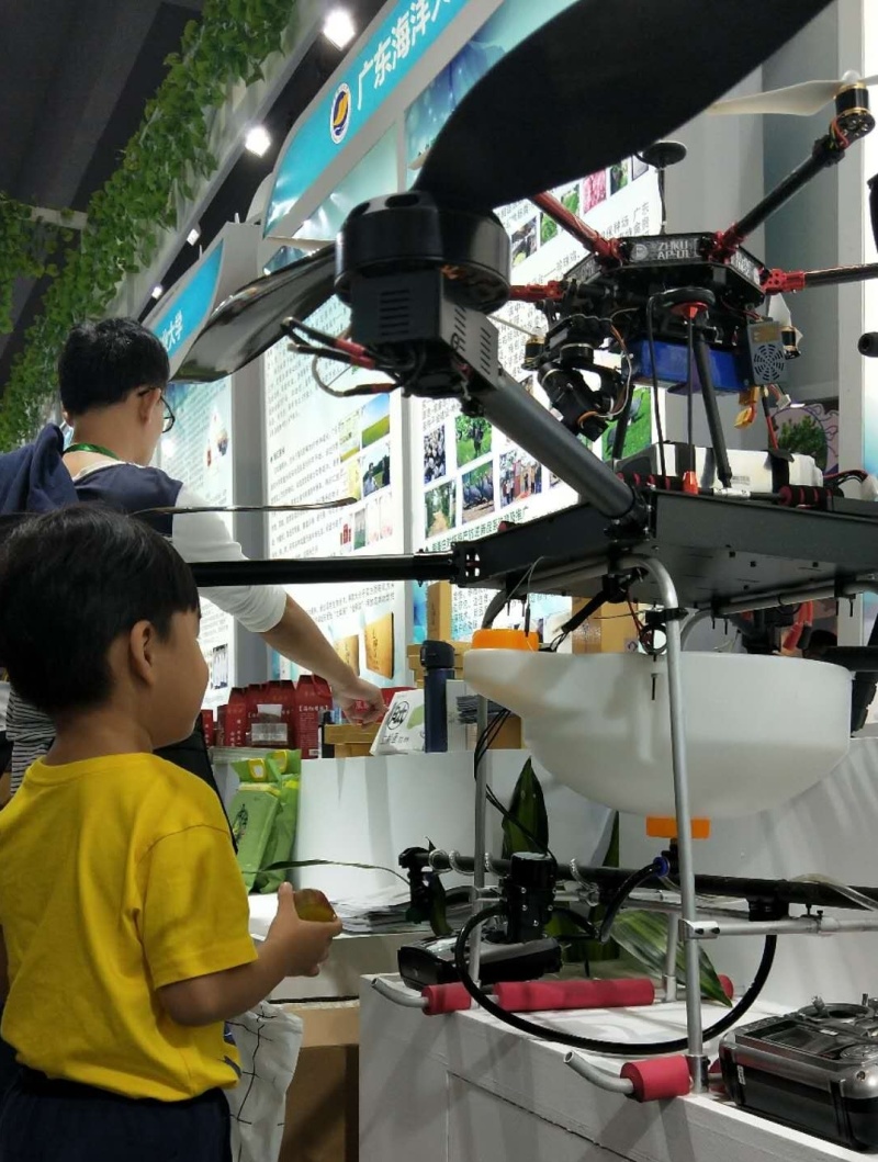 在仲恺农业工程学院展位上，展出的电动多旋翼造型农业植保无人机吸引了小朋友的眼球。