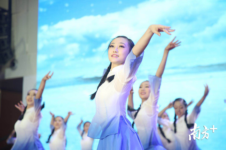 深中学生舞蹈团带来《沁园春·雪》,象征着新的时代,为新的办学目标所鼓舞的,全体深中人的精神与意志。身着白蓝色裙子的姑娘们伴着雪花翩翩起舞,青春的笑脸洋溢着对深中的热爱。老照片里是光阴,新面孔里有欣喜,今日凤凰树下,我们重温青春最动人的诗篇。