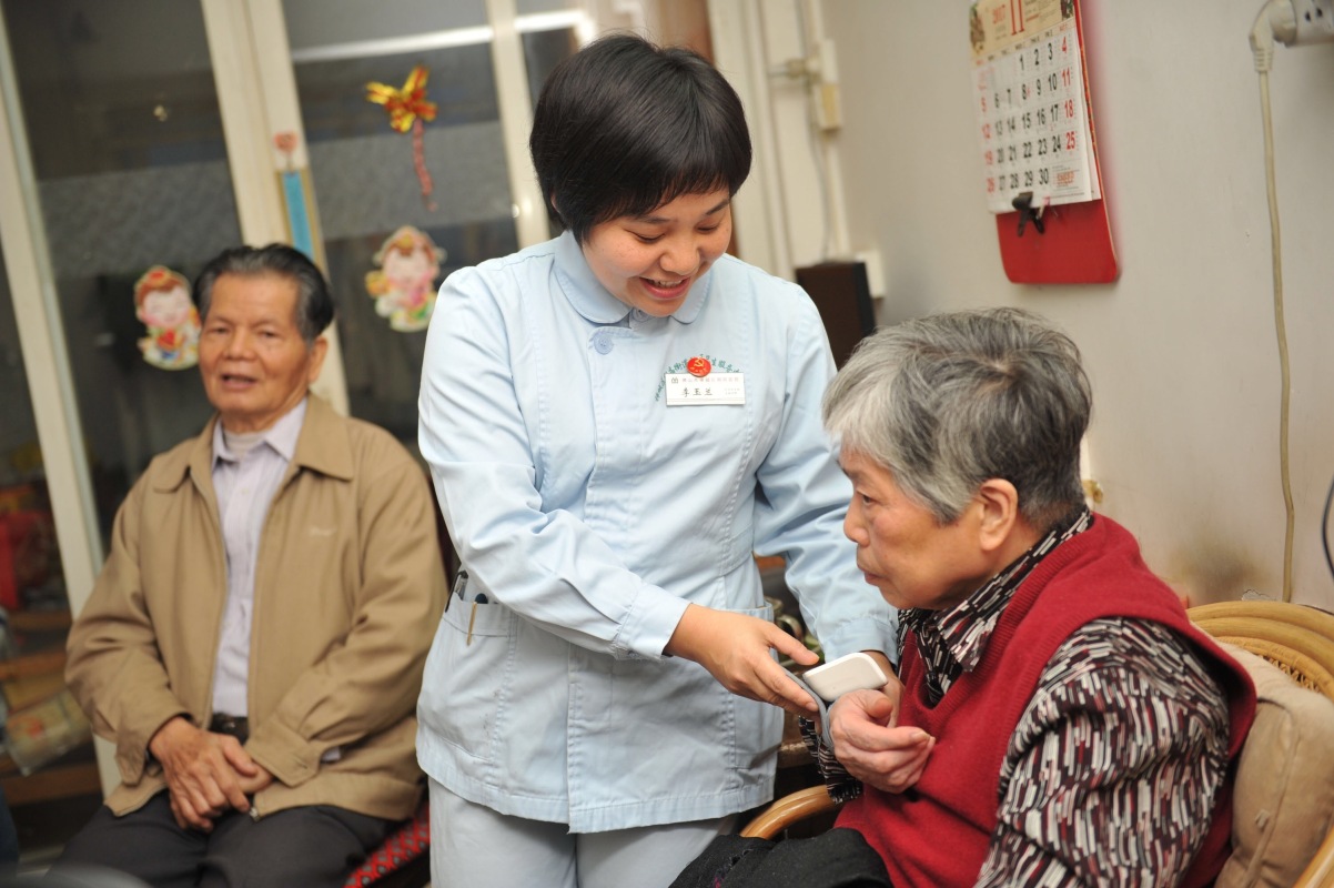 陈三妹社区卫生服务中心的家庭医生李玉兰上门为老人进行探访和医治.