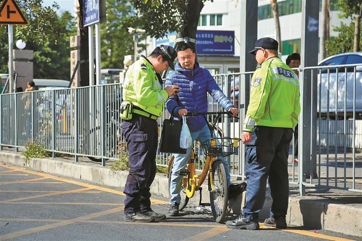 交警查處騎共享單車違法的行人.深圳晚報記者 馬超 攝