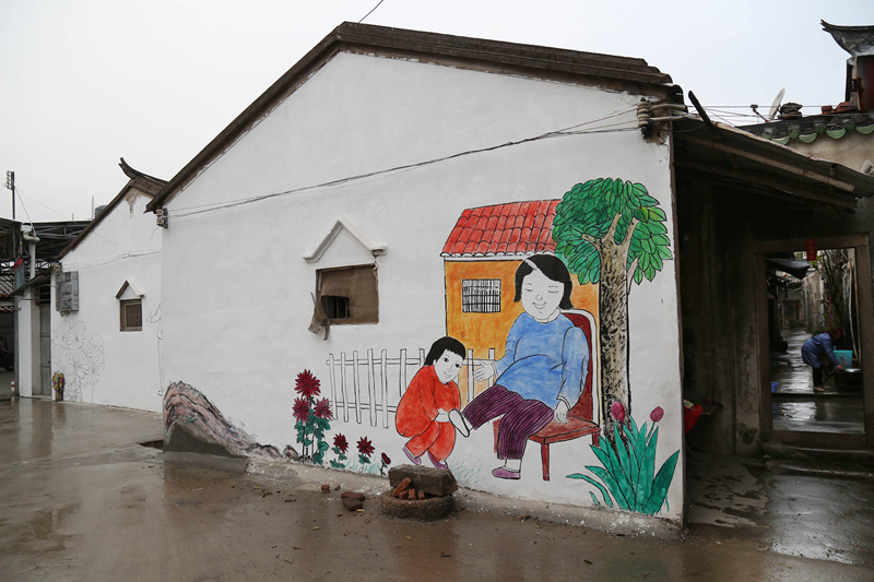 古巷镇枫洋二村，村里将老厝的旧墙刷白，并请当地人画上传统绘画。