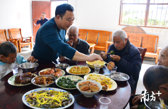 欧阳战海为敬老院老人夹菜。2001年起,在每年的中秋、重阳、春节等节日,欧阳战海都会给敬老院老人“加菜”,18年来从未间断。南方日报记者黄津 摄 欧阳战海为敬老院老人夹菜。2001年起,在每年的中秋、重阳、春节等节日,欧阳战海都会给敬老院老人“加菜”,18年来从未间断。南方日报记者黄津 摄