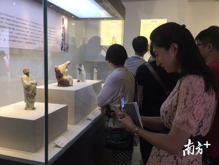 陶艺爱好者边看展边拍照。 陶艺爱好者边看展边拍照。