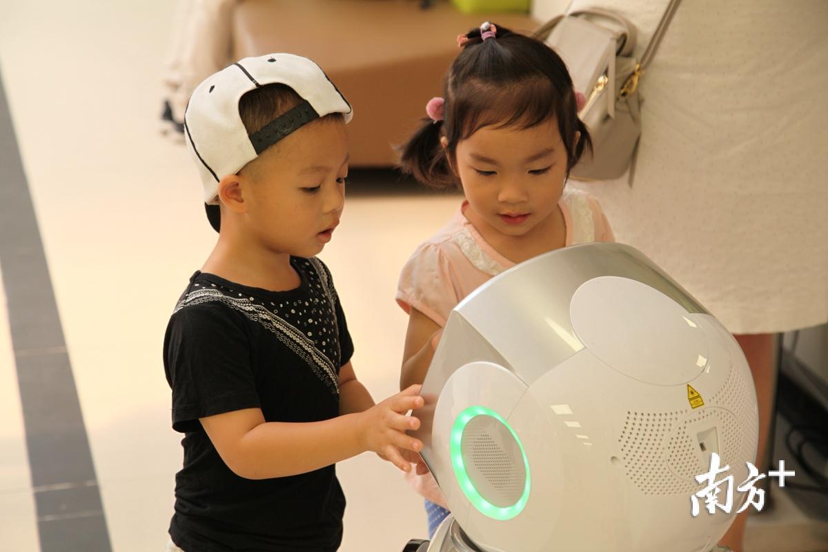 儿童保健中心候诊大厅的娱乐机器人吸引了不少儿童