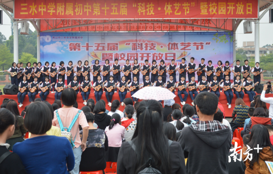 今年的校园开放日上，三中附中学生在图书馆前用尤克里里弹唱英文歌。 马永钊 摄 