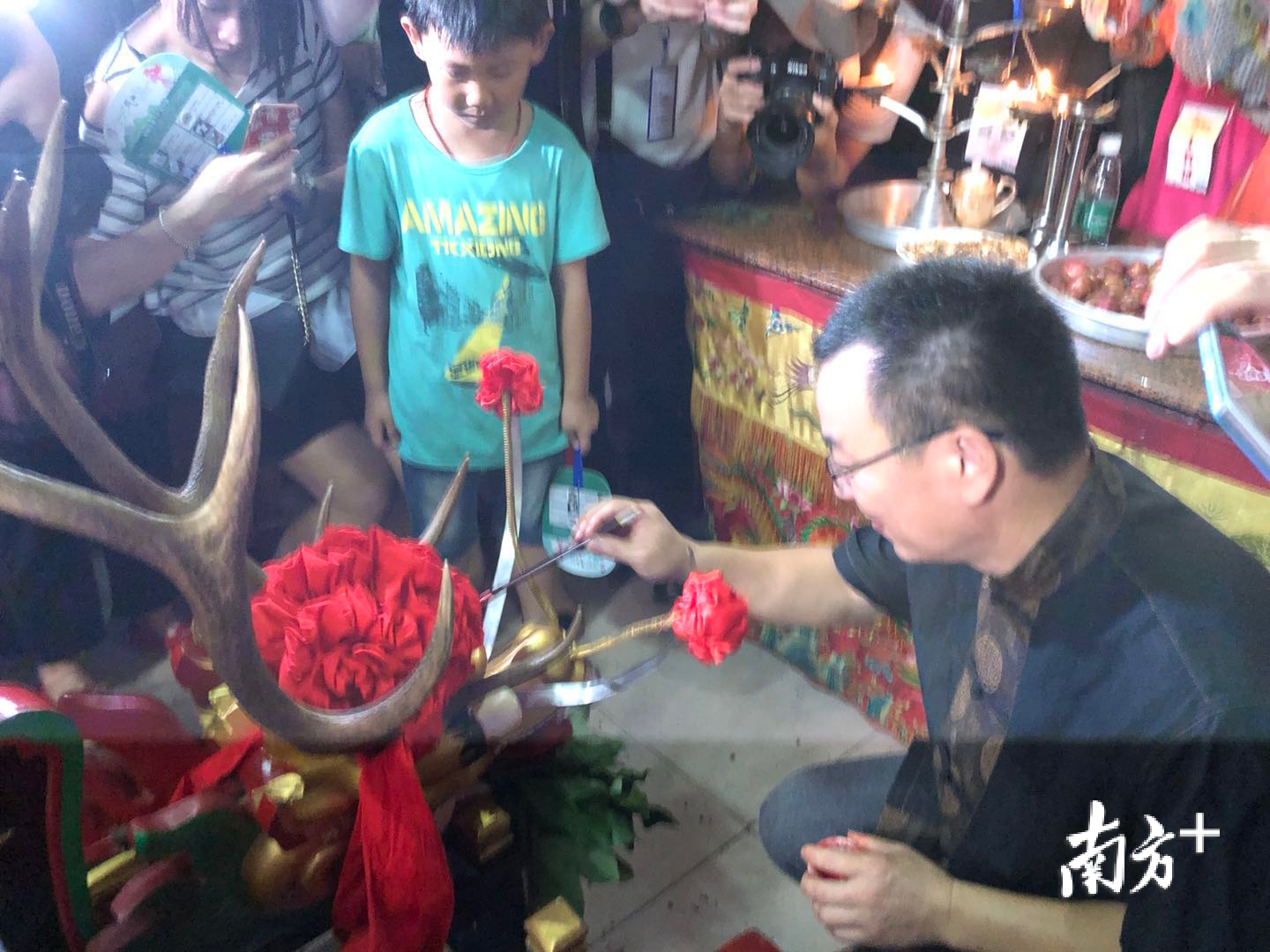 太尉庙里，“龙眼点睛”习俗传承人梁汉勇正在为龙舟进行点睛。