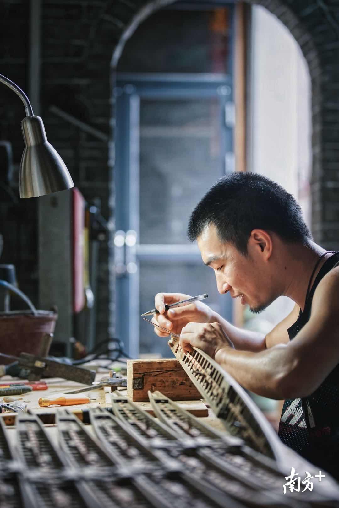 △为了更好地传承龙头制作工艺,张伟潮近些年来也尝试收徒传授自己的手艺,图为张伟潮的徒弟阿华在制作龙舟模型。 △为了更好地传承龙头制作工艺,张伟潮近些年来也尝试收徒传授自己的手艺,图为张伟潮的徒弟阿华在制作龙舟模型。