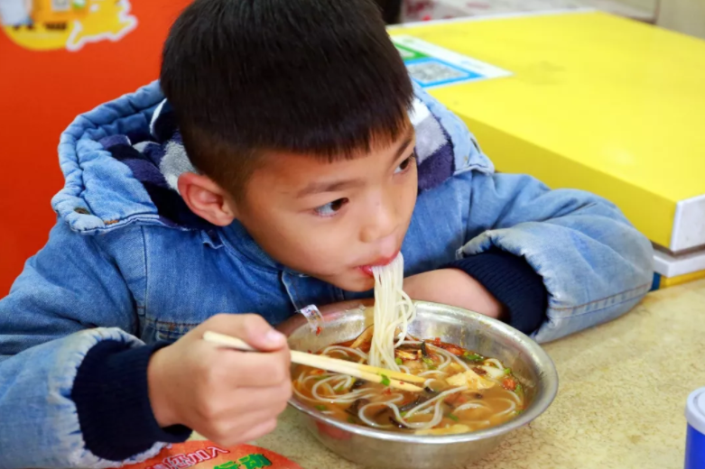 一位小顾客在津津有味地“唆”粉。王予照摄