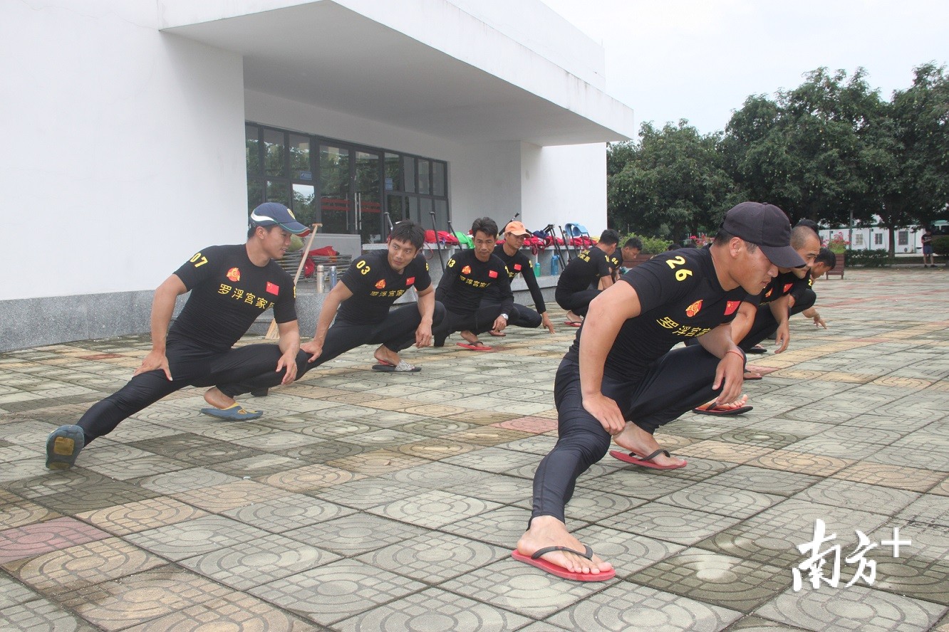 下水训练前，中国男子龙舟队员们开展热身拉伸运动。欧阳少伟 摄