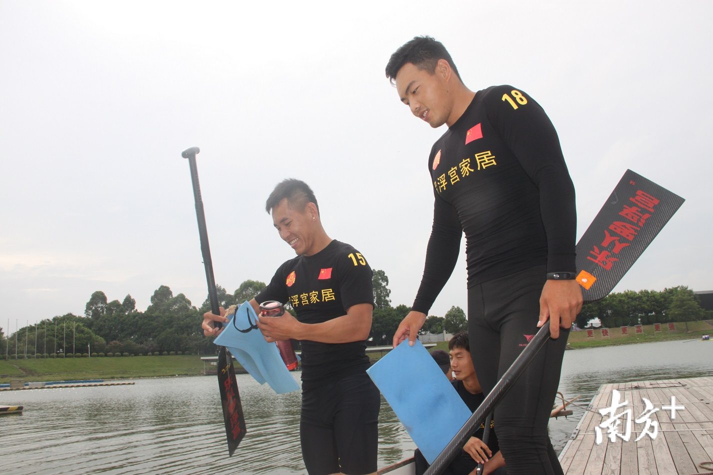 队员们手持划桨，登上龙舟。 欧阳少伟 摄