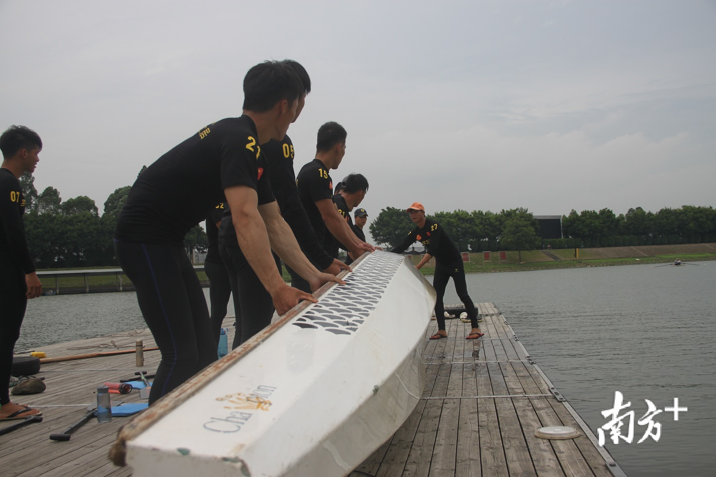 队员们结束水上训练时，整齐地抬起龙舟上岸。欧阳少伟 摄
