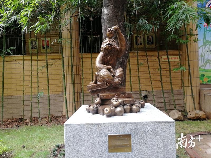 许鸿飞捐赠的作品《猴顿苹果》，一只灵动猴子坐在的一摞《万有引力》的书籍上，手捏苹果咧嘴笑。