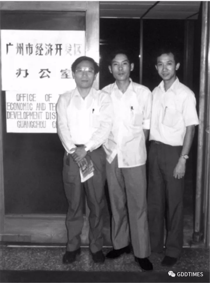 筹备组成员在东方宾馆1262室前合影，中英文的招牌均为手绘。