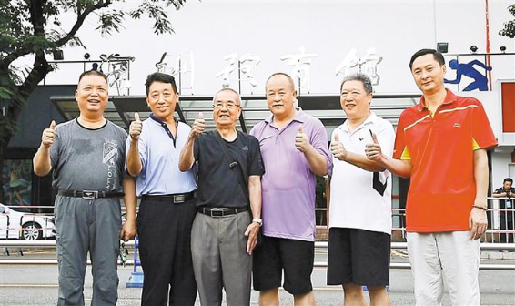 深圳体育馆第一任馆长张加秀（左三）与同事在即将面临改造的深圳体育馆前合影留念。图片来源：读创客户端