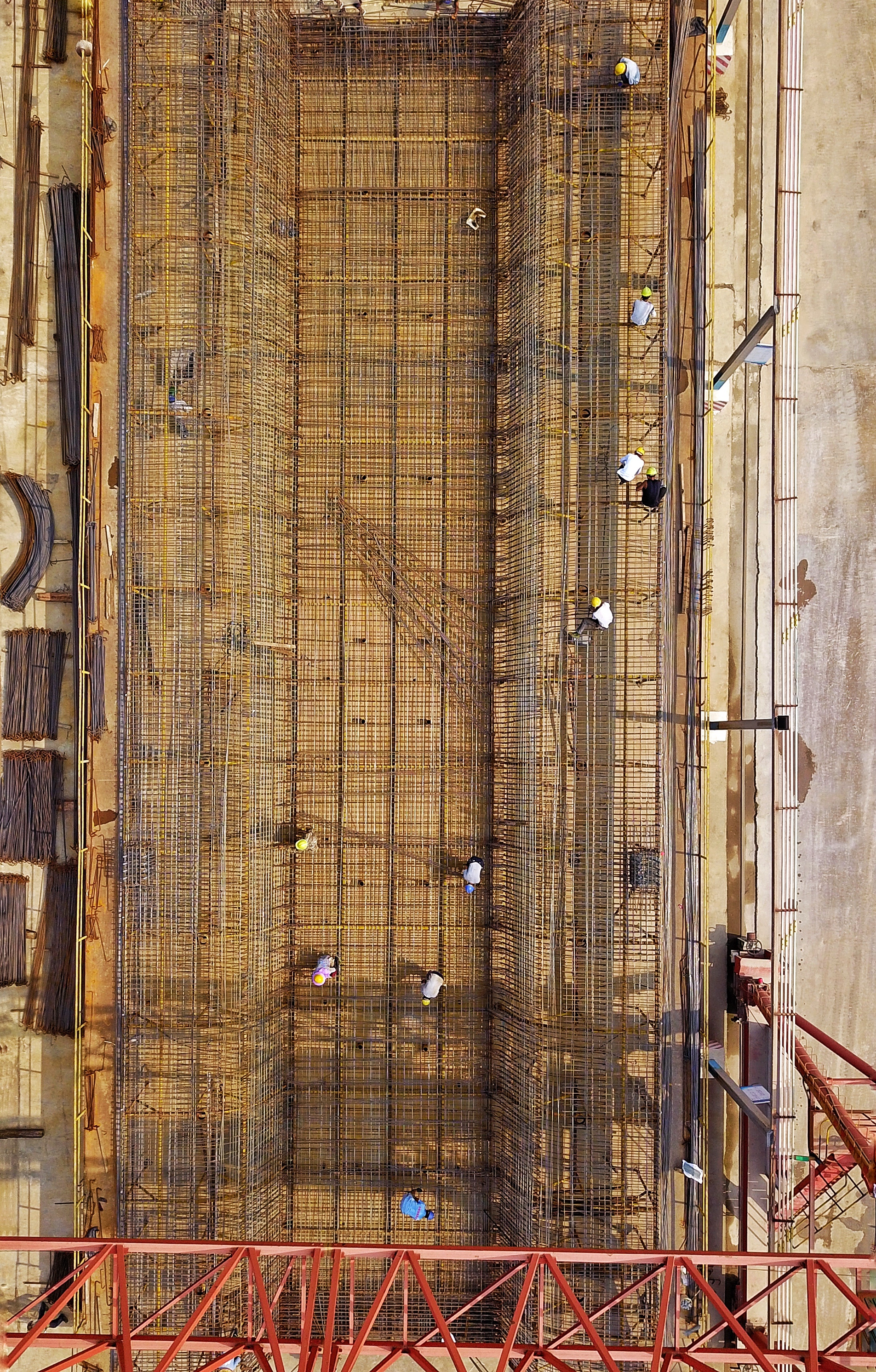 酷暑时节,梅州当地不是高达37摄氏度的高温天气,就是伴随着阵雨的台风天气。对这种情况,高铁工人们也已经“习惯了”。图为工人们在绑扎钢筋。 酷暑时节,梅州当地不是高达37摄氏度的高温天气,就是伴随着阵雨的台风天气。对这种情况,高铁工人们也已经“习惯了”。图为工人们在绑扎钢筋。