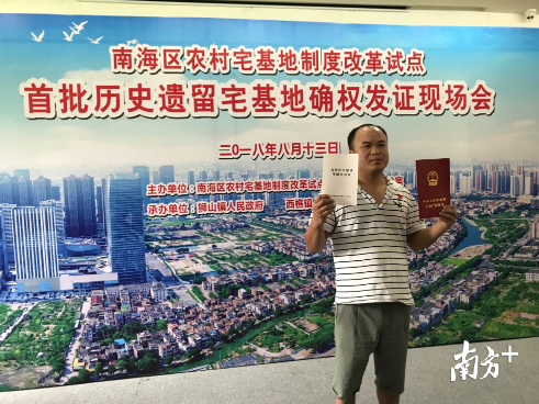 时隔13年，周宝成领取到属于自家房屋的不动产权证书，“无名之家”终于能够如愿确权。李欣 摄