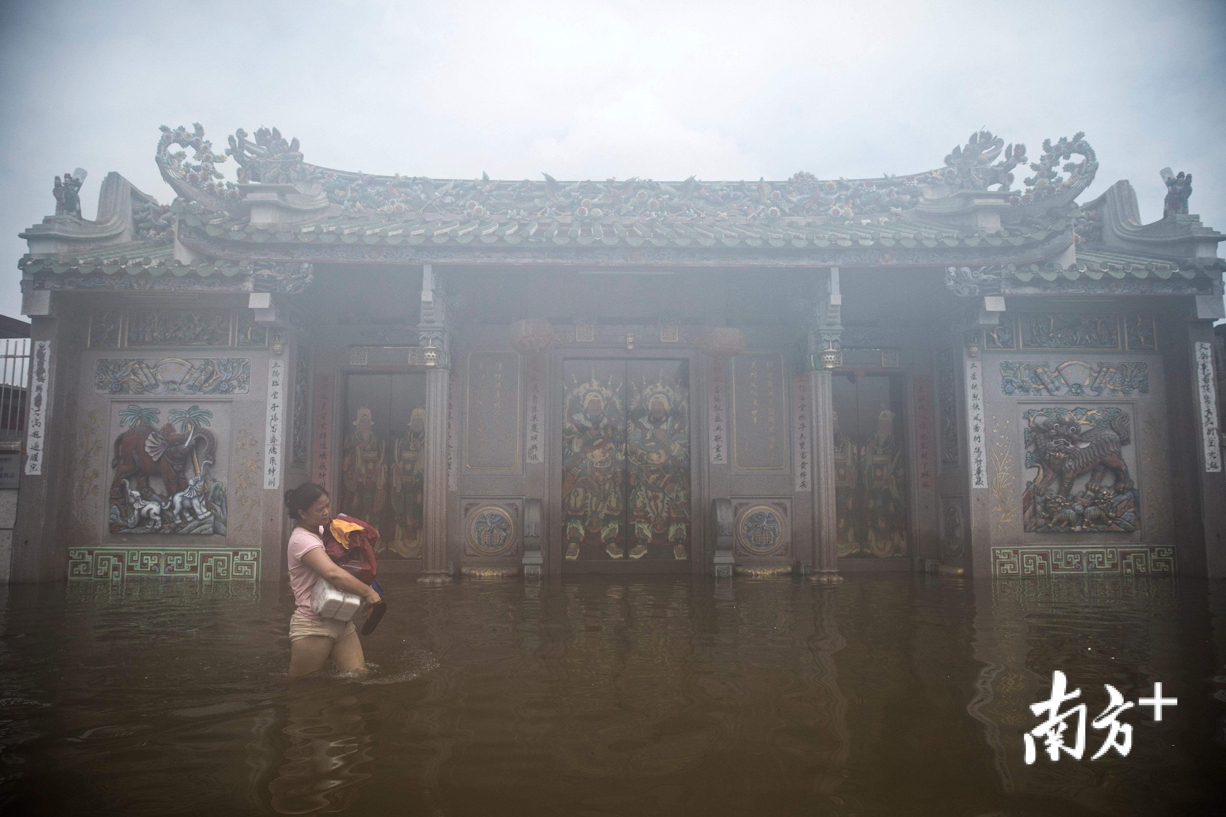 △9月2日，陈店镇北沟村依然被洪水浸泡，一名村民抱着食物蹚水而过。