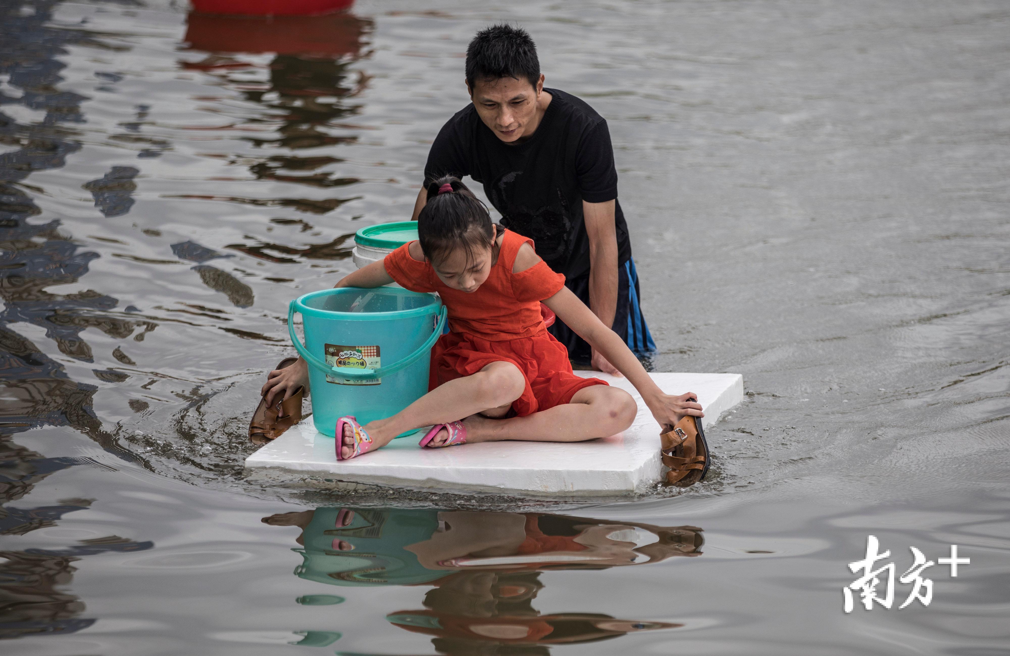 △9月2日，陈店镇港后村，一位家长用泡沫板将孩子送出。