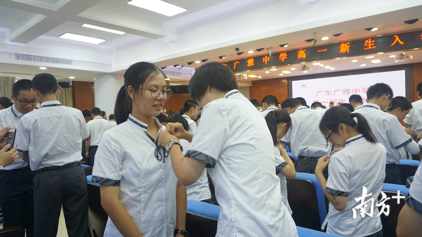 广雅新生为同侪佩戴校徽。