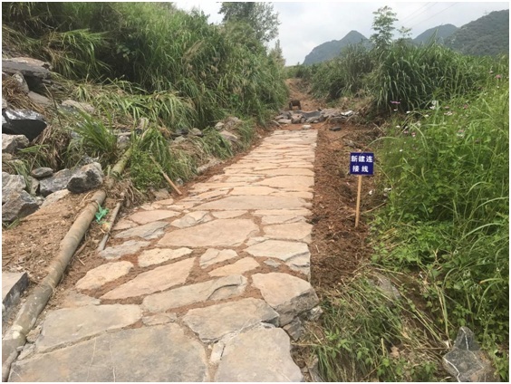 图为施工人员正在用三合土铺设西京古道连接线.