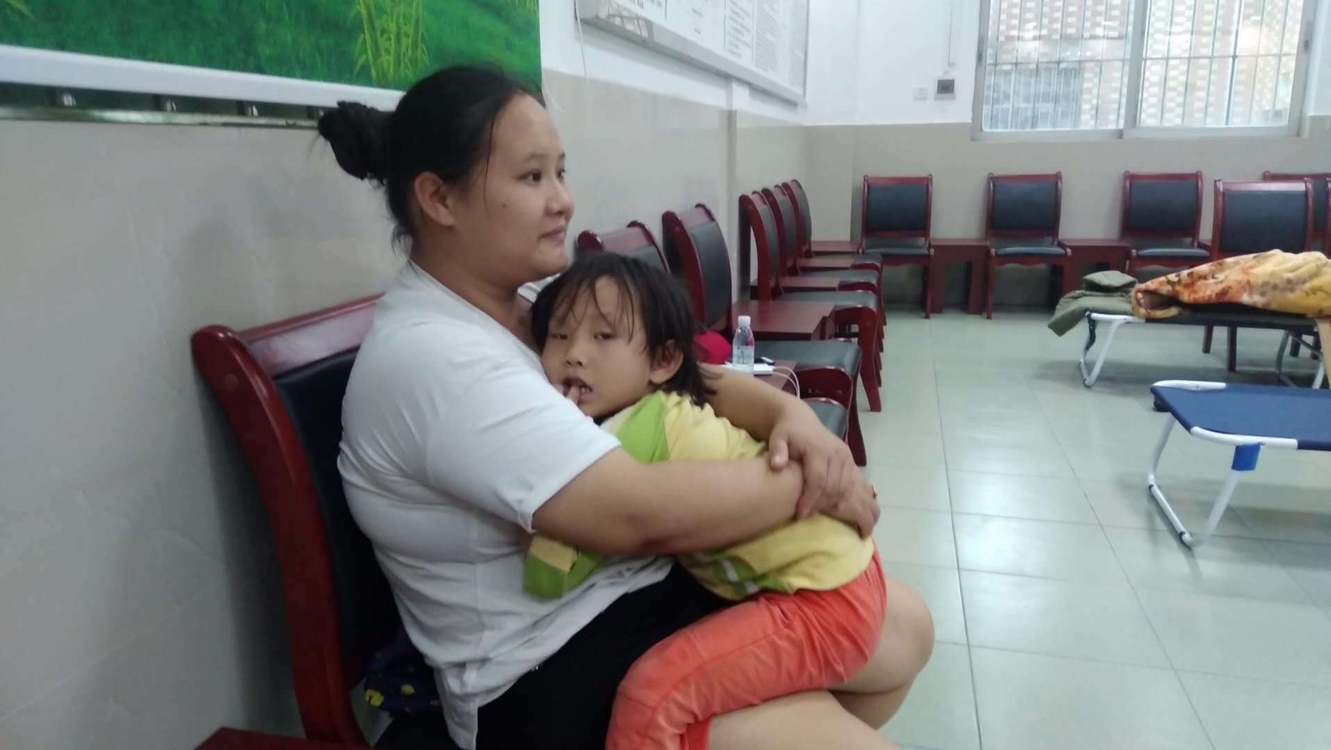 16日下午2时许,在古鉴村三楼庇护室里,湖南籍的胡琳搂着自己的4岁女儿。欧阳少伟摄 16日下午2时许,在古鉴村三楼庇护室里,湖南籍的胡琳搂着自己的4岁女儿。欧阳少伟摄