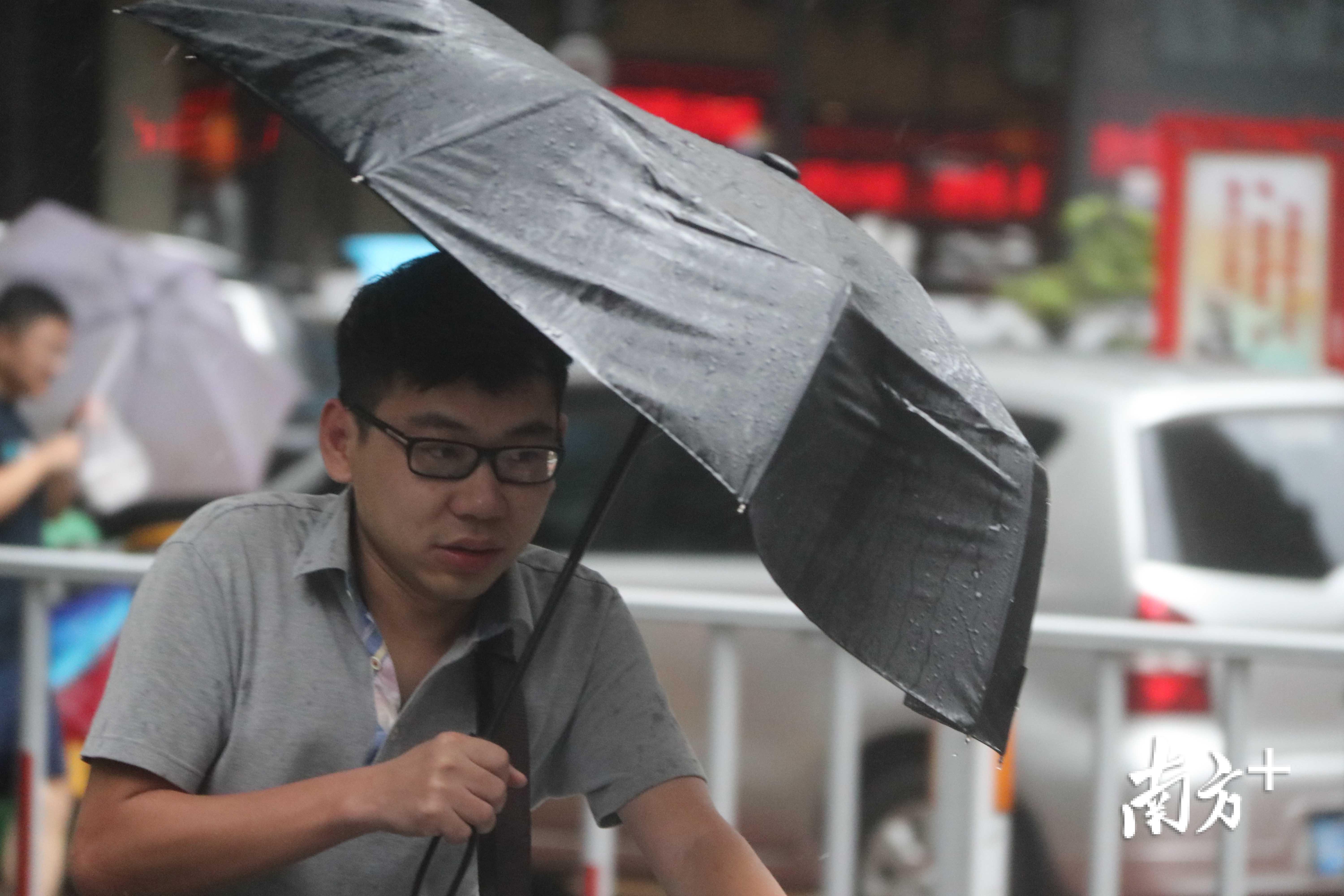 市民冒雨前行.【摄影】姚军