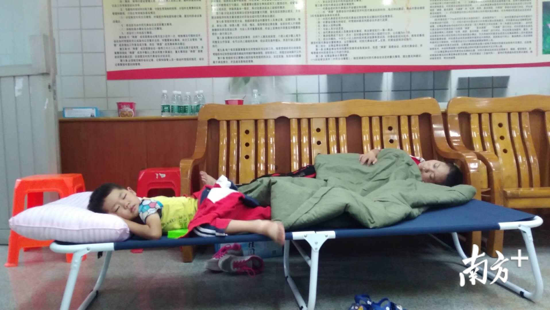 16日下午2时13分,在古鉴村二楼会议室内安睡的李先花母子。欧阳少伟摄 16日下午2时13分,在古鉴村二楼会议室内安睡的李先花母子。欧阳少伟摄