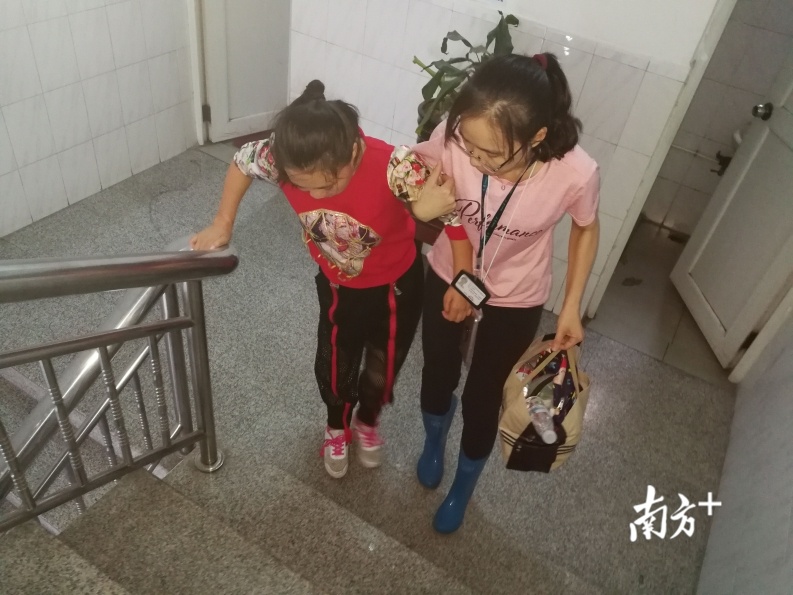 16日上午10时许,由于李先花有腿疾,古鉴村委委员王丽青搀扶着李先花上二楼的会议室。受访者供图 16日上午10时许,由于李先花有腿疾,古鉴村委委员王丽青搀扶着李先花上二楼的会议室。受访者供图