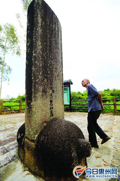 一名老人在认真看下马石上的文字记载。 