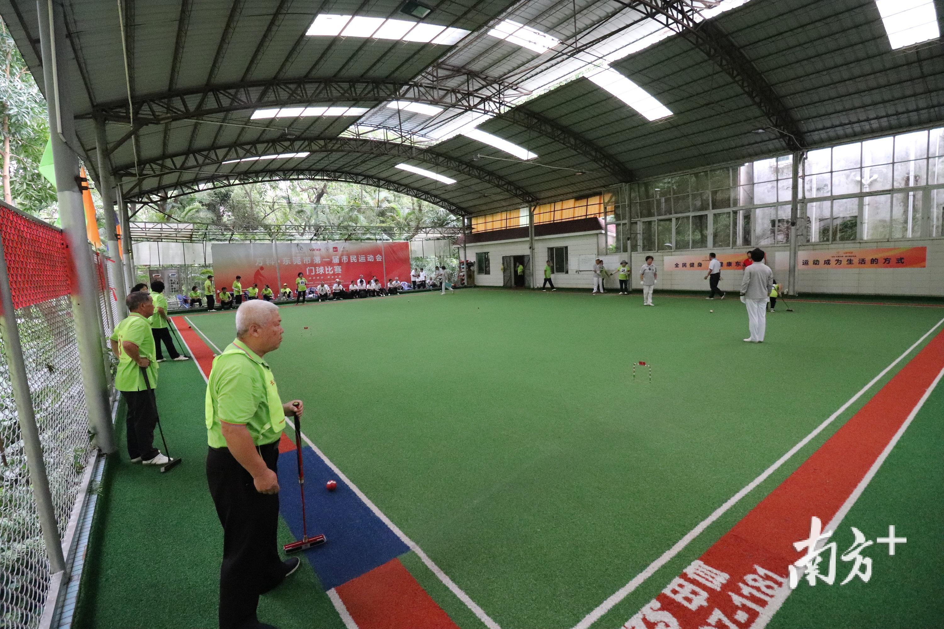 门球赛场上你来我往,几个小球围着球门在转动。(麦炜源摄) 门球赛场上你来我往,几个小球围着球门在转动。(麦炜源摄)