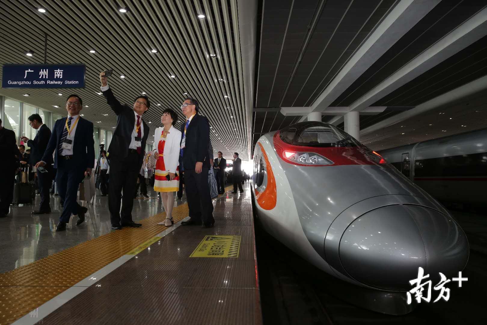 “动感号”抵达广州南，列车上的客人纷纷来到车头合影留念。