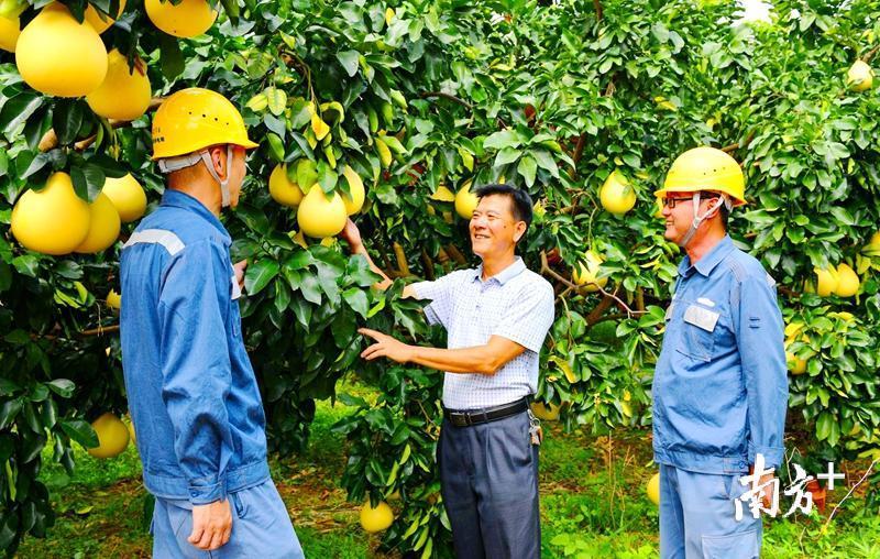 供电人员与当地村民交流。温红 摄