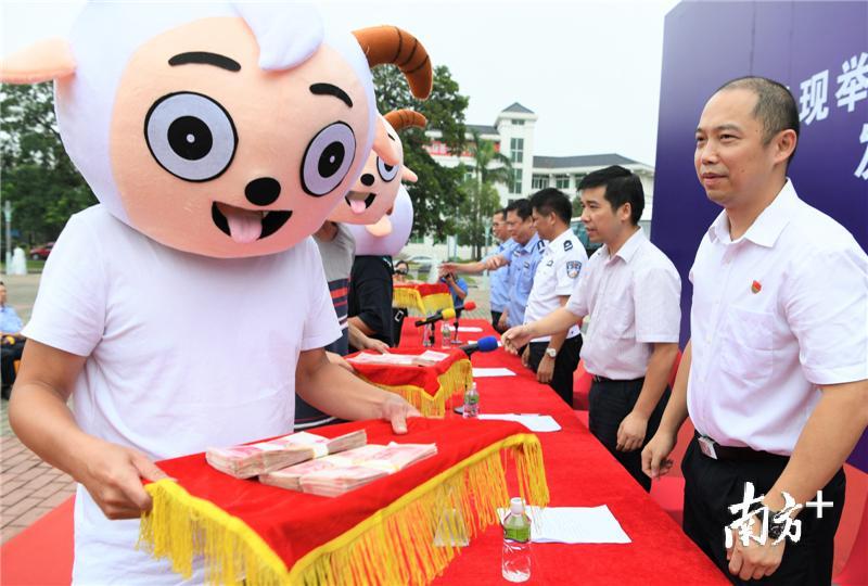 举报人头戴喜羊羊面具领走奖金。杨兴乐 摄