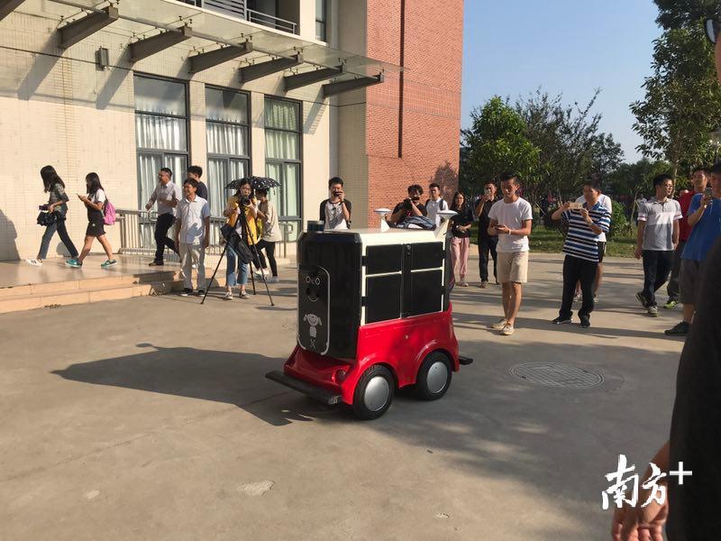 红色底座，黑色身形。方方正正 的身体上设置了众多的摄像头和传感器。这个小不点就是即将投入使用的机器人快递员。