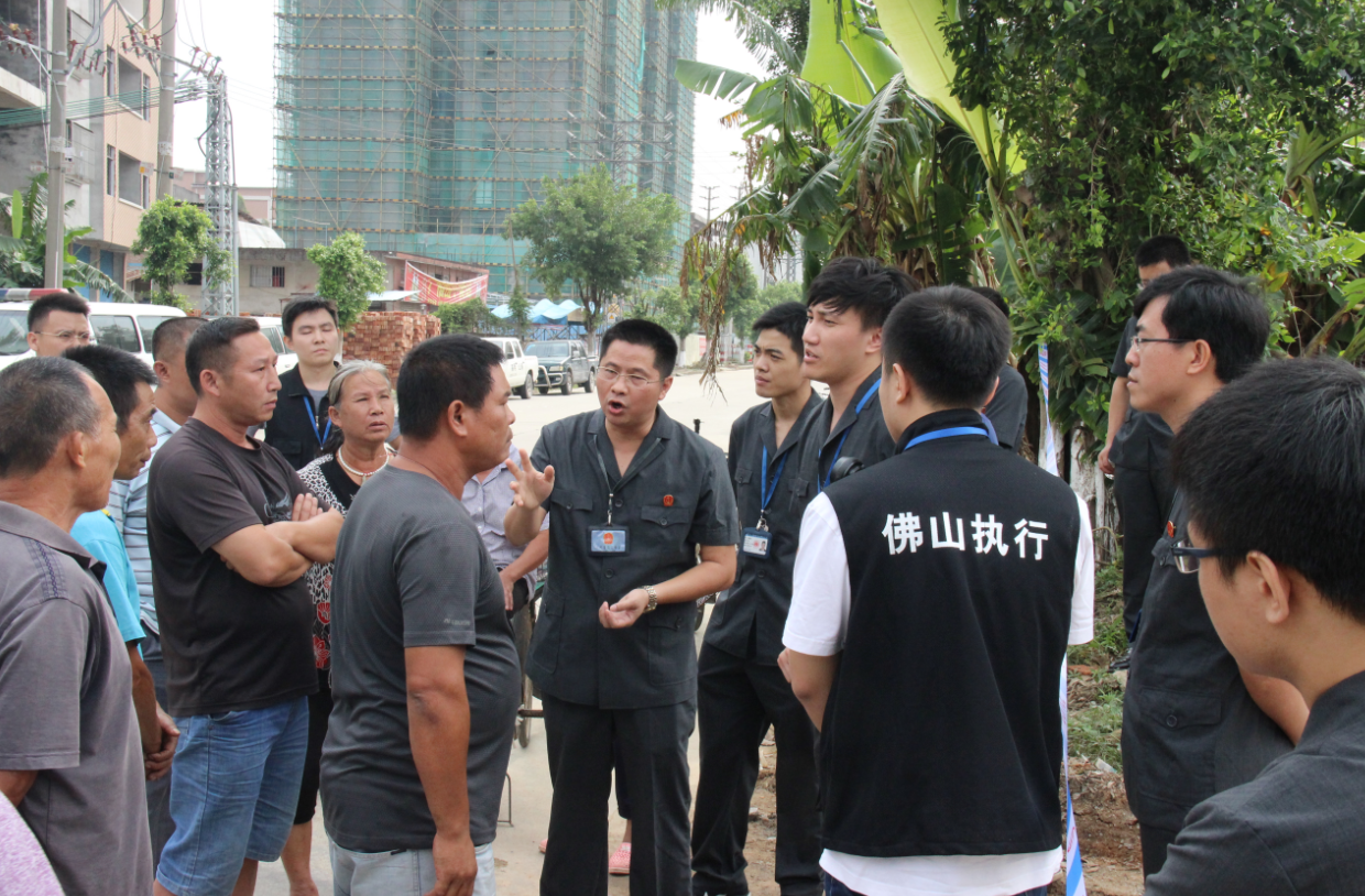 法院执行干警在现场向围观群众解释相关法律。 法院执行干警在现场向围观群众解释相关法律。