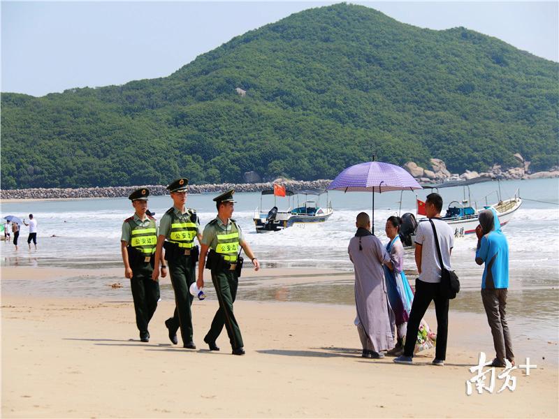 汕头边防支队深澳边防派出所的官兵在辖区青澳湾海滩巡逻,在叮嘱群众注意带好随身物品。刘建高 摄 汕头边防支队深澳边防派出所的官兵在辖区青澳湾海滩巡逻,在叮嘱群众注意带好随身物品。刘建高 摄